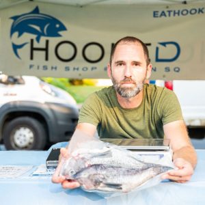 Man holding fish at Hooked stand